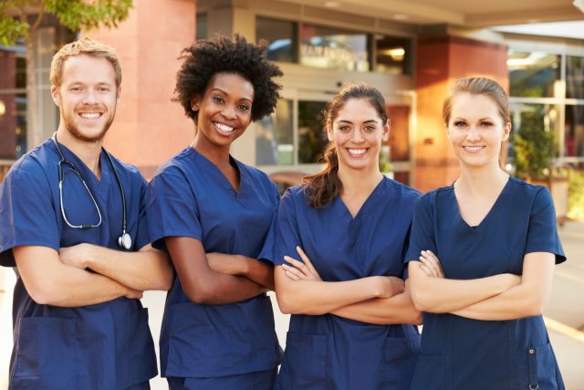 four healthcare professionals are posing for a picture