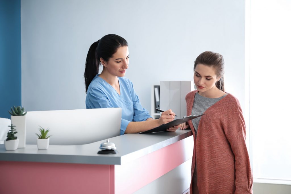 Medical Office Administrator Checking In A Patient