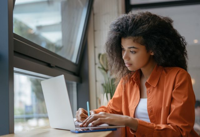 A younf female student is studying on her laptop