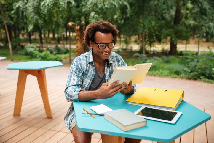 Online student reading outside