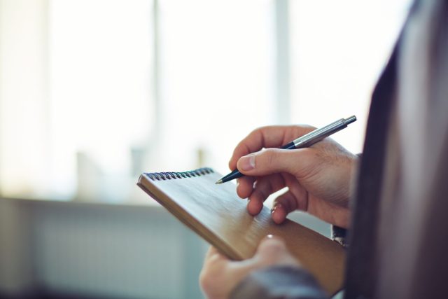 Upclose of someone writing on a notepad