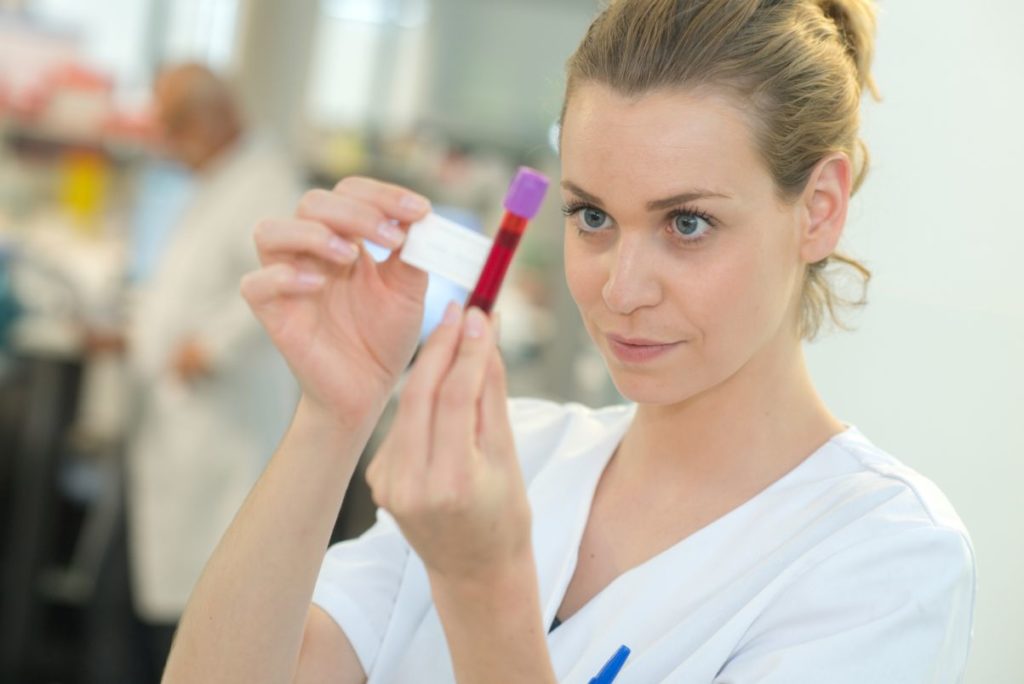 Medical assistant labeling a phlebotomy sample (blood sample)