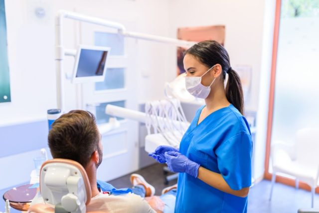 A Dental assistant is speaking with a patient