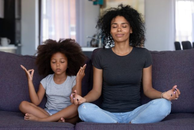 A mom and a daughter are doing yoga